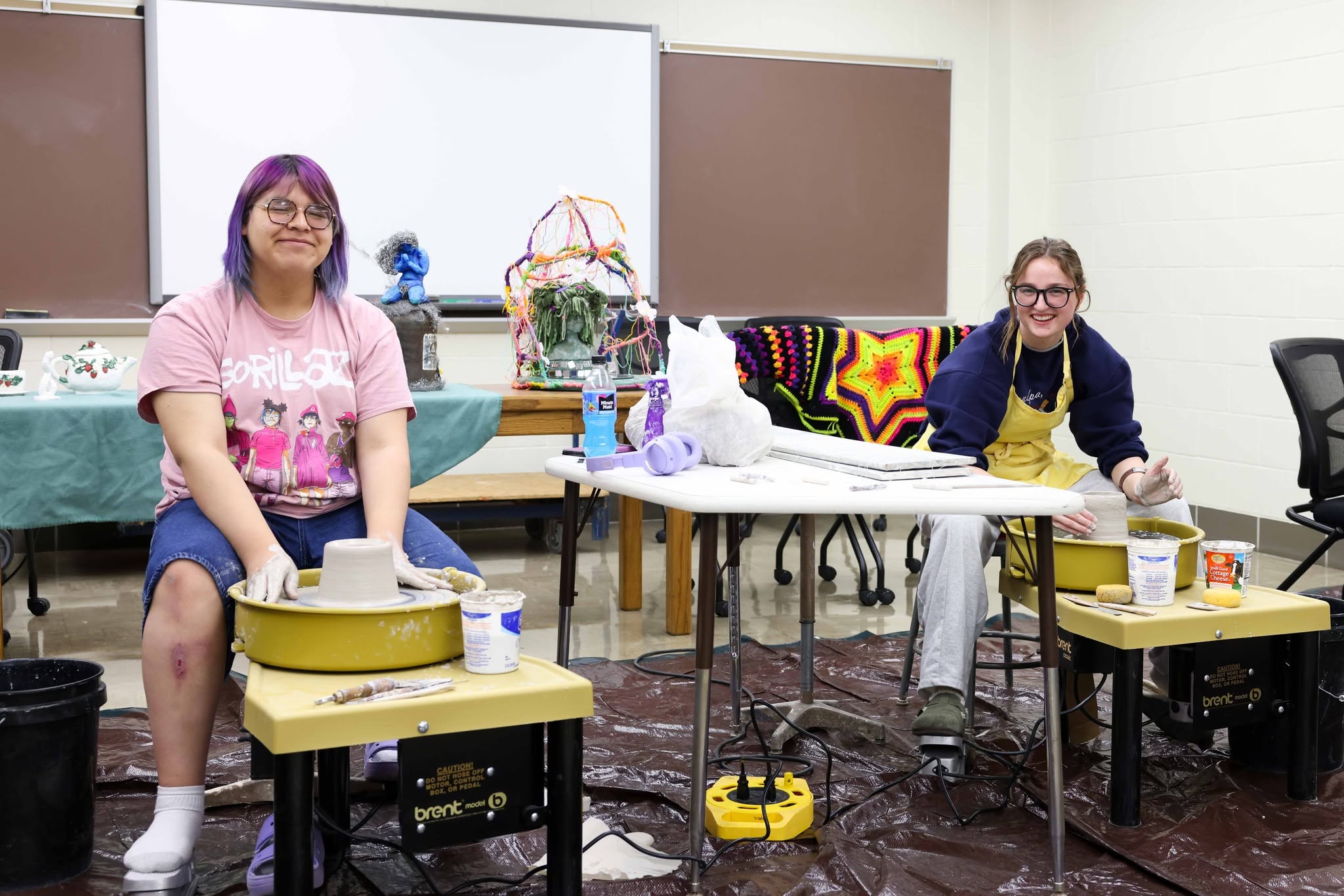2 Art students demonstrating pottery wheels