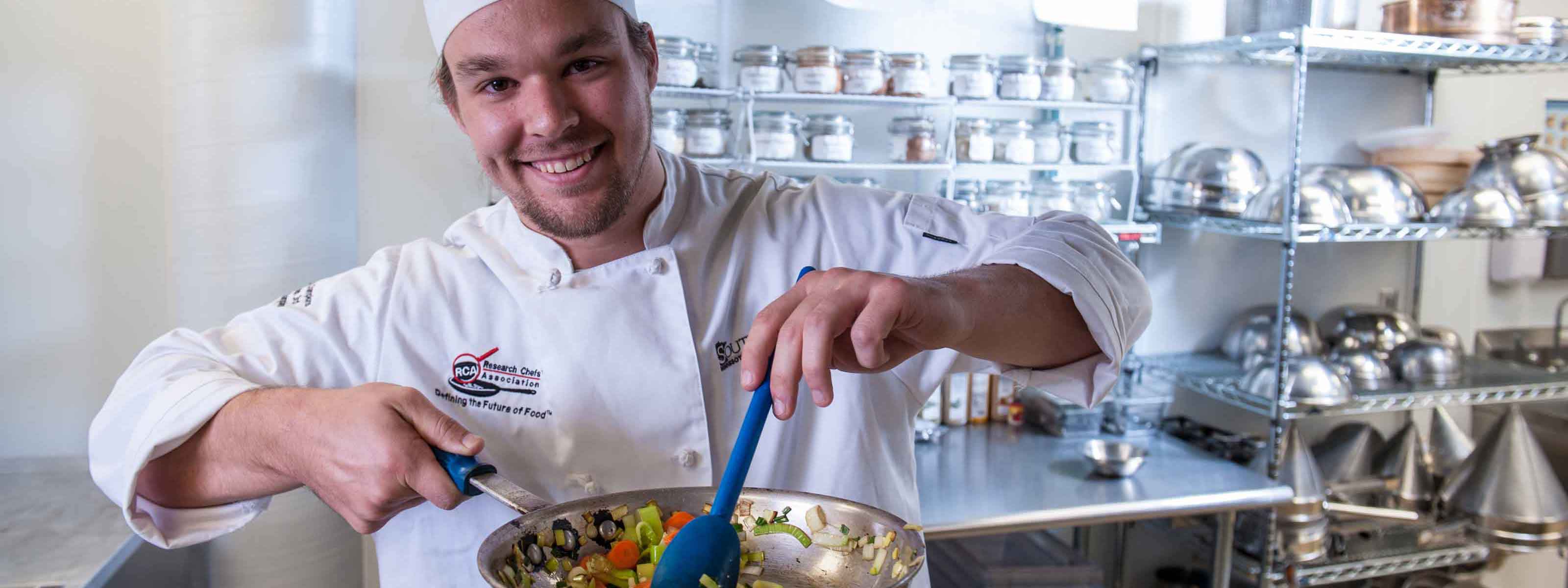 Culinology student stirring vegetables