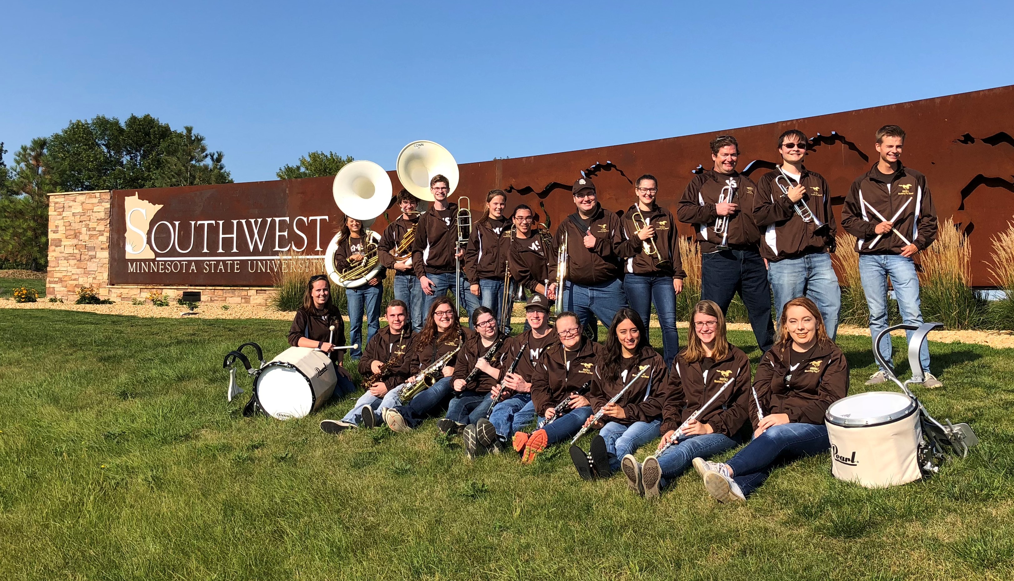 picture of the 2018 Mustang Pep Band in front of the University sign