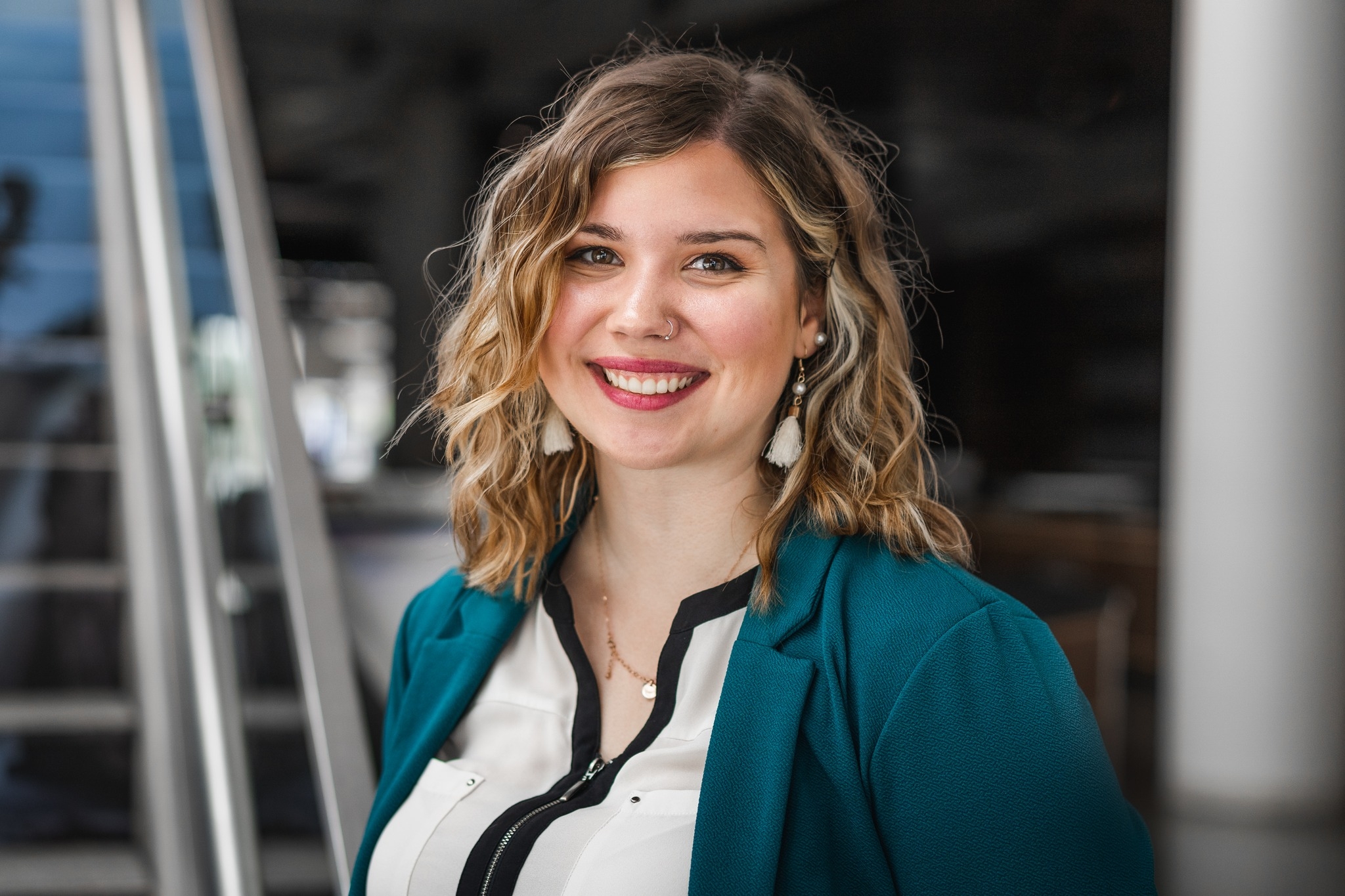 Doria Dorst's headshot. Doria is wearinf a white top, and a blue blazor. Doria has blonde wavy hair.