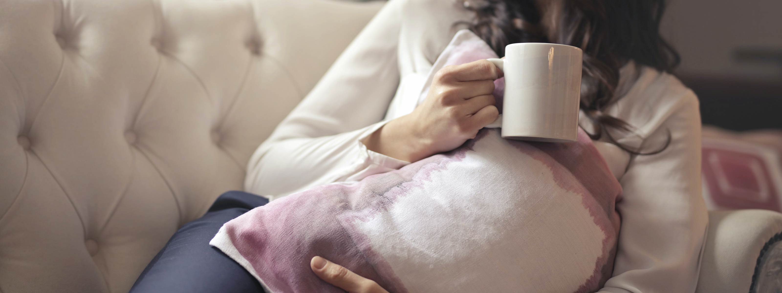 Woman lying on couch with mug