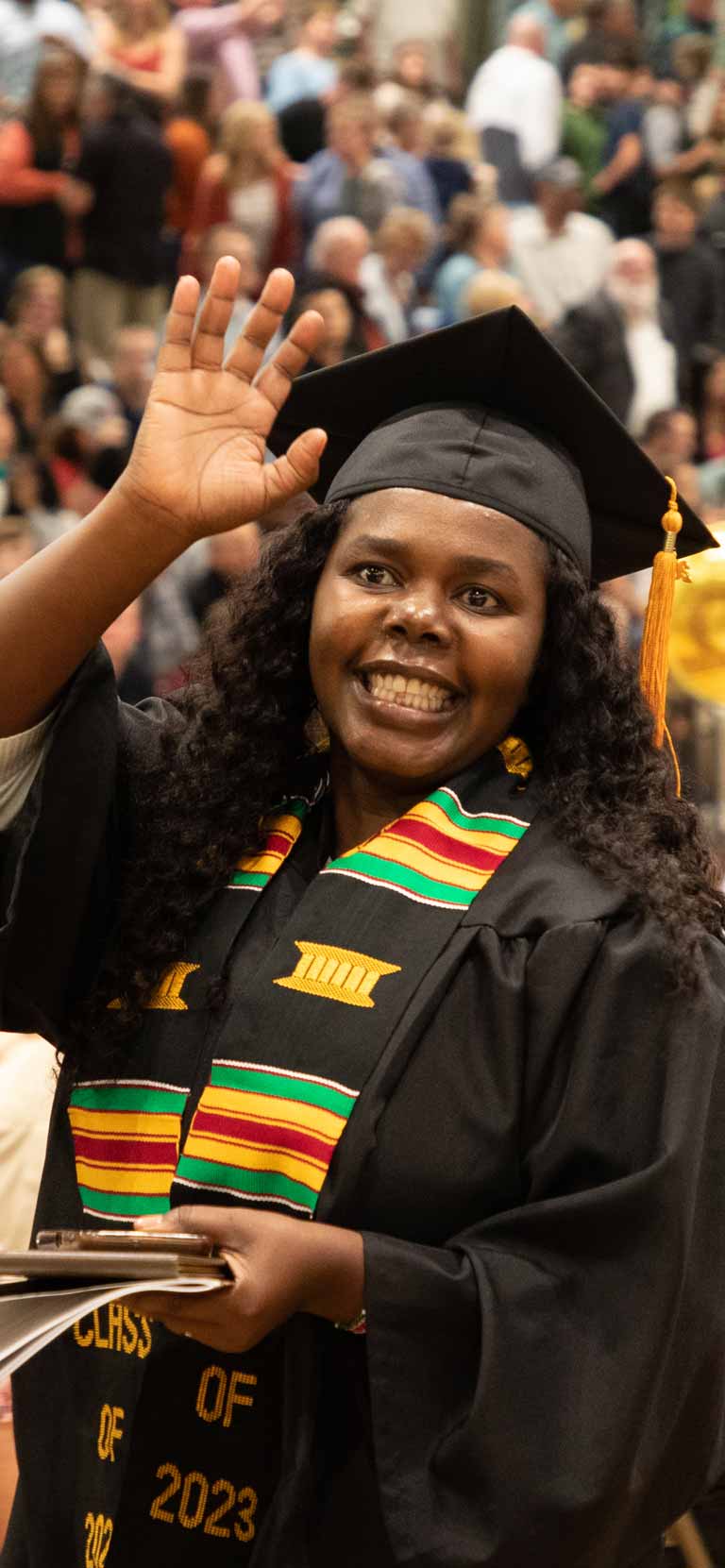 Commencement student waving their hand