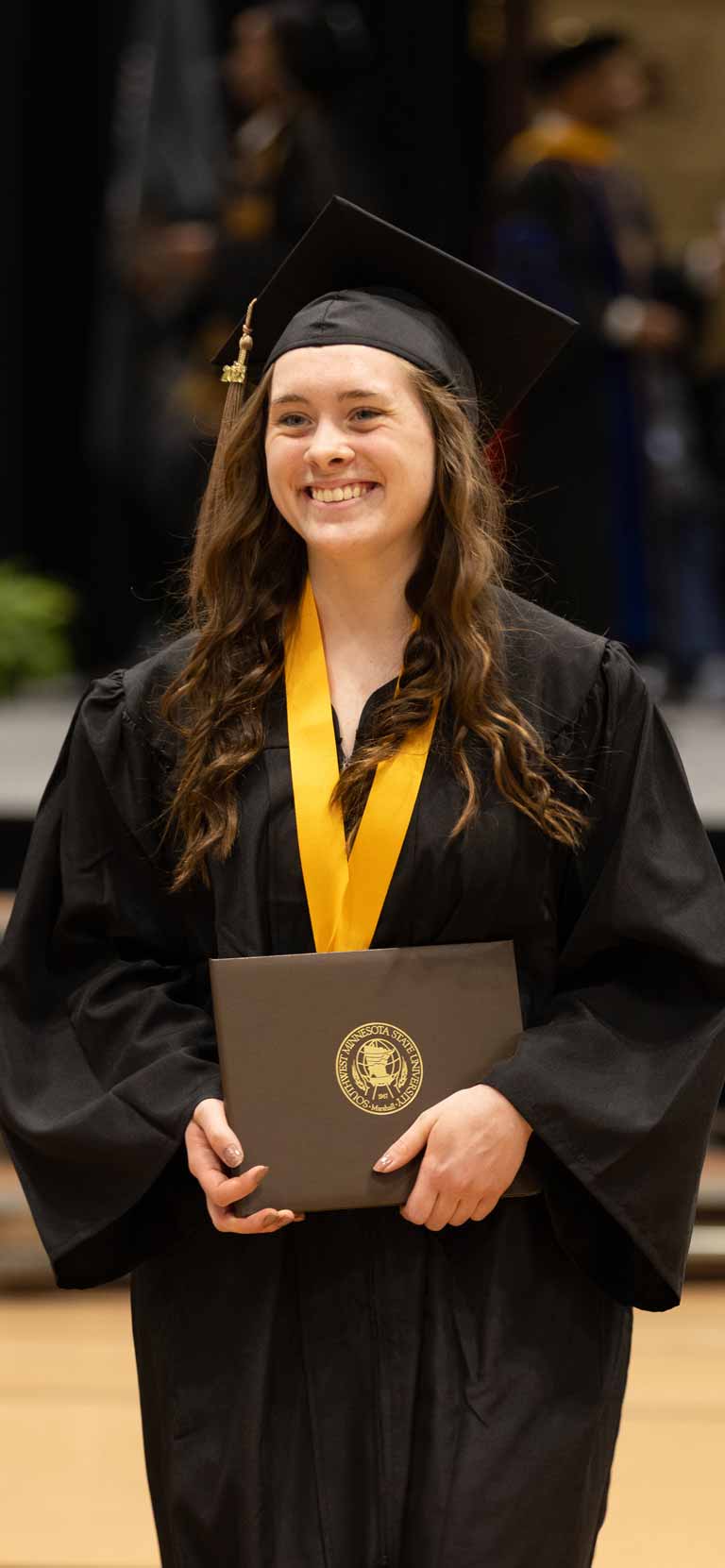 Commencement student holding degree