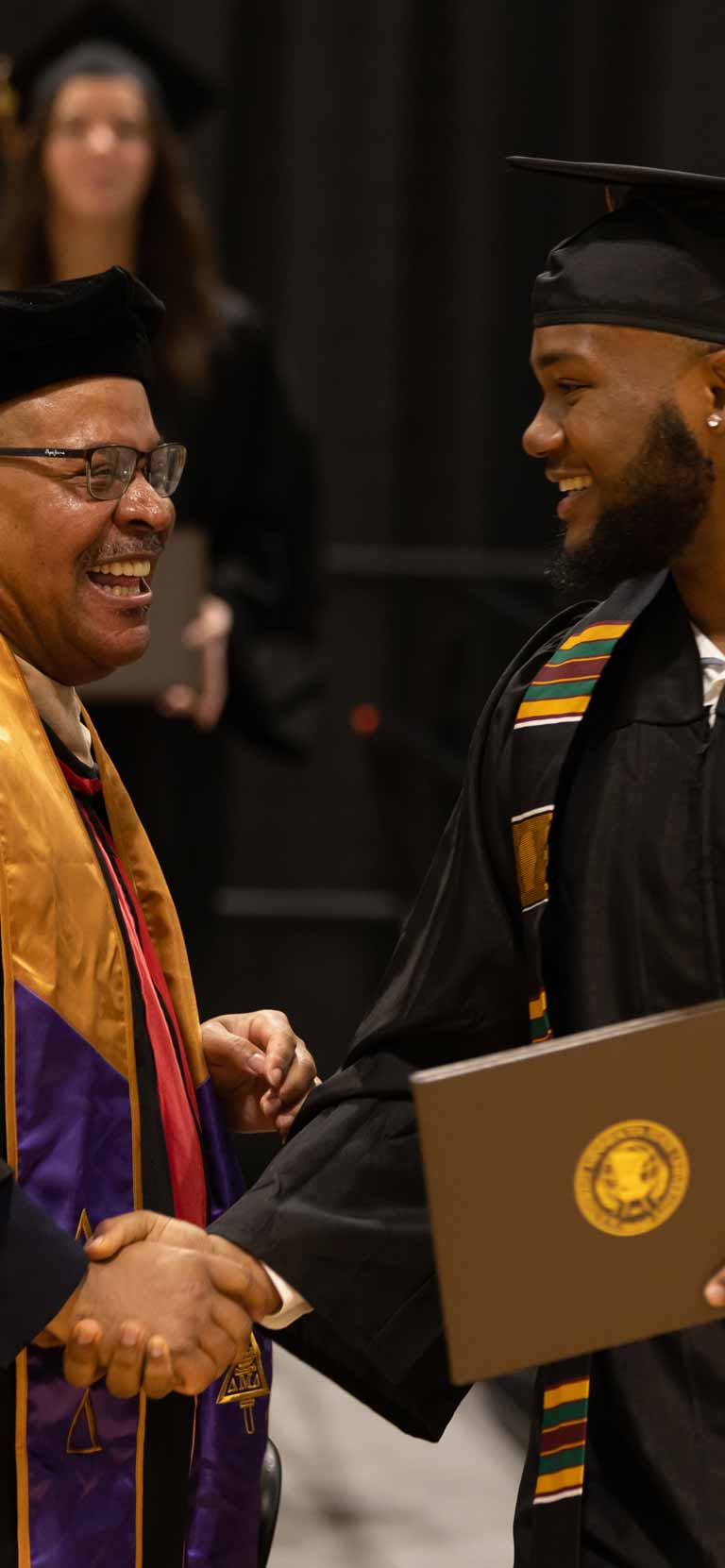 Photo of a professor and student shaking hands