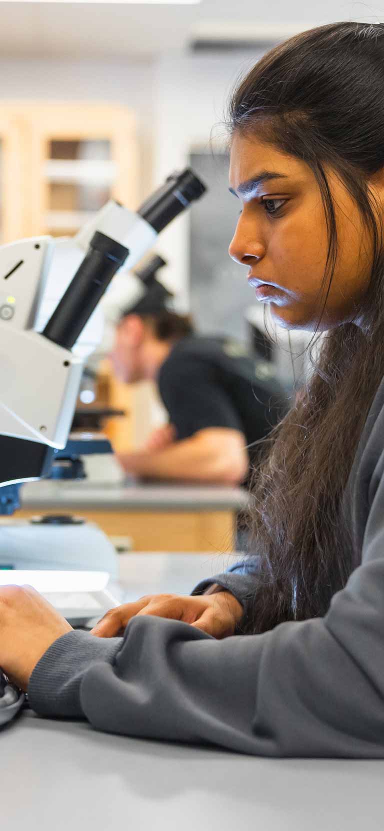 Photo of student with microscope