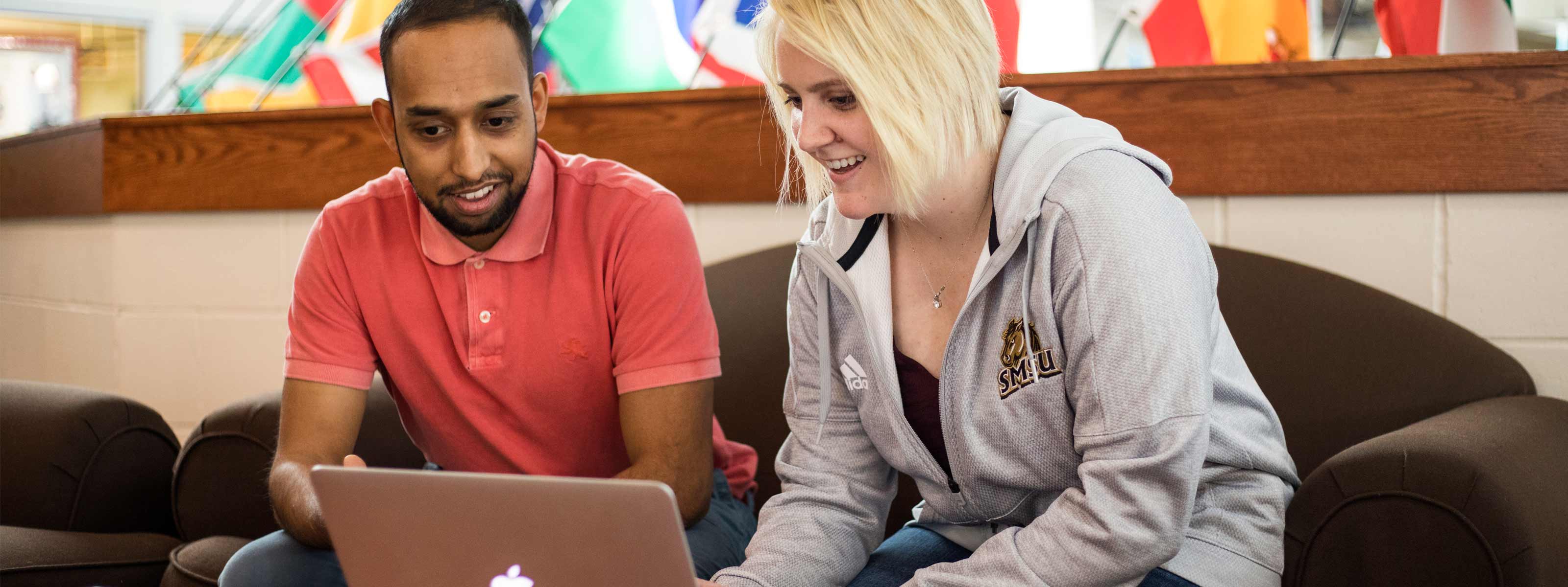 Students looking at a laptop computer